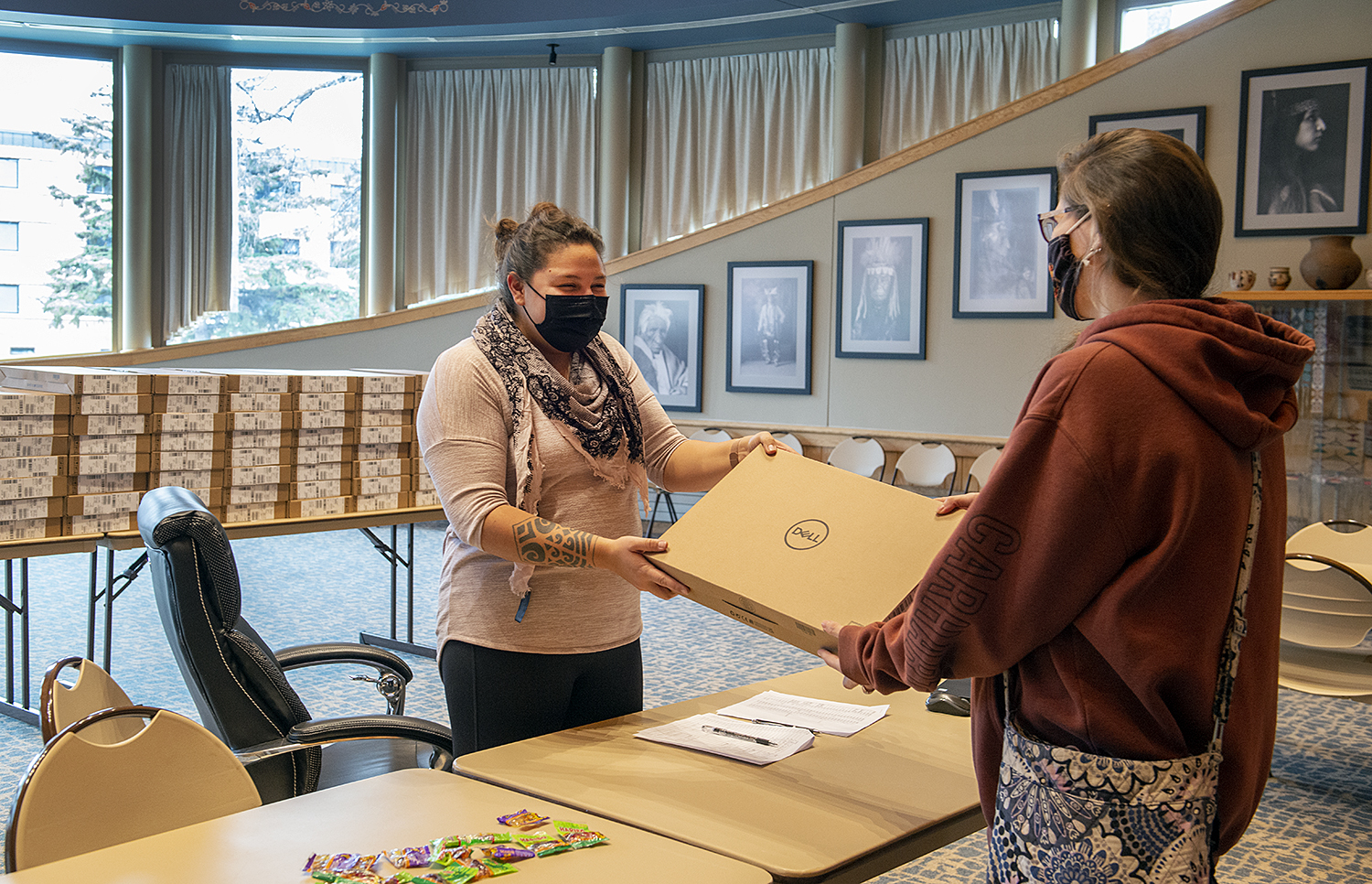 Ann Humphrey, associate director of retention at Northwest Tech's American Indian Resource Center, handing a laptop to a grant recipient