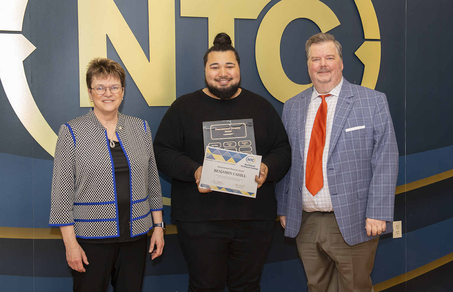 Benjamin Cahill holding his demonstrated diversity award and plaque.