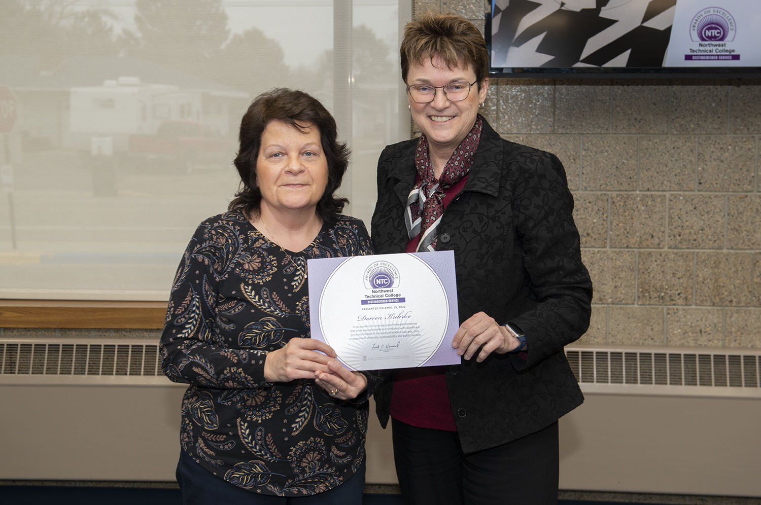 President Faith Hensrud presenting Doreen Kuhrke, administrative assistant, the NTC Distinguished Service Award.