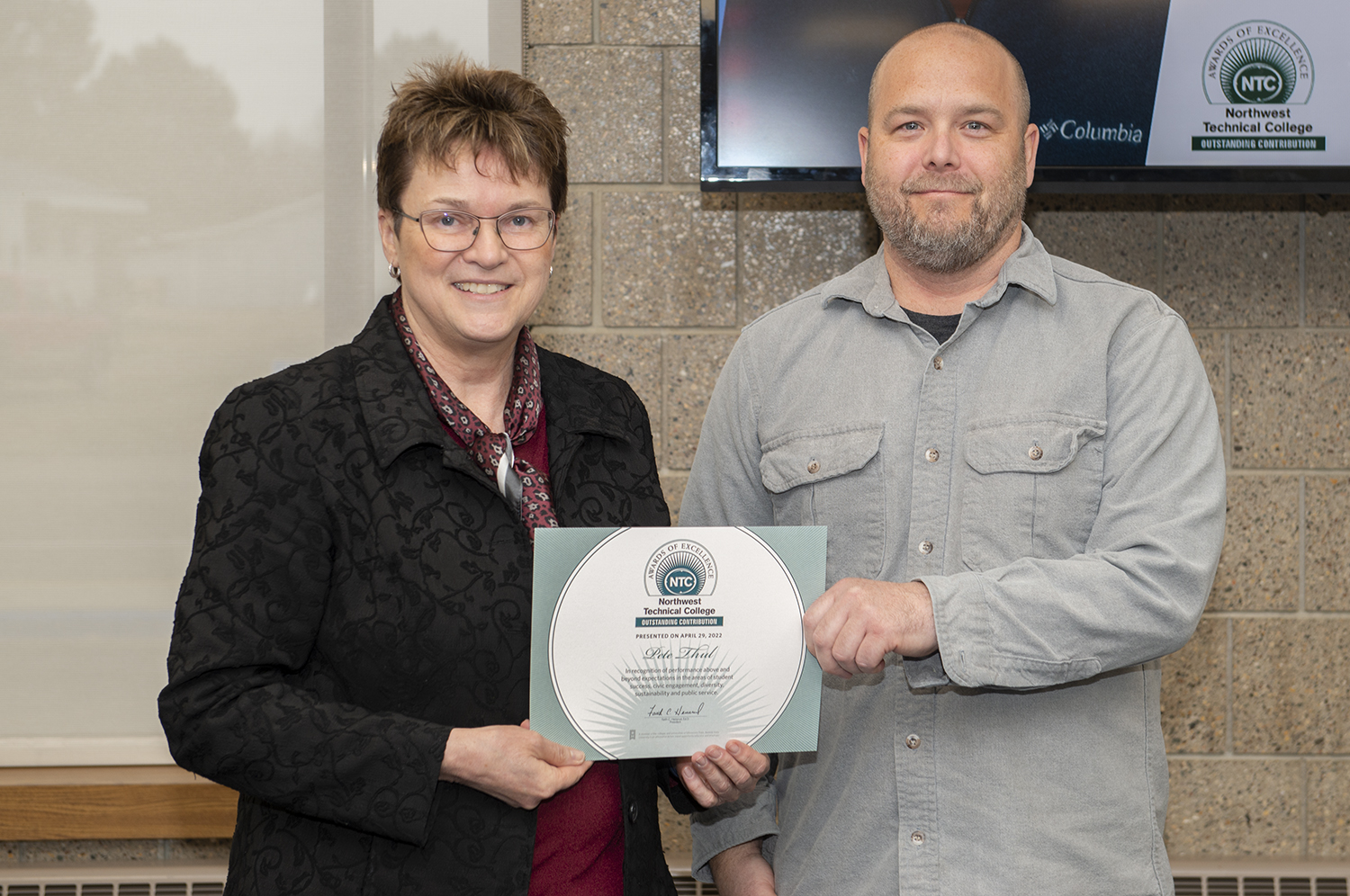 President Faith Hensrud presenting Peter Thul, electrical faculty, the Outstanding Contribution award.