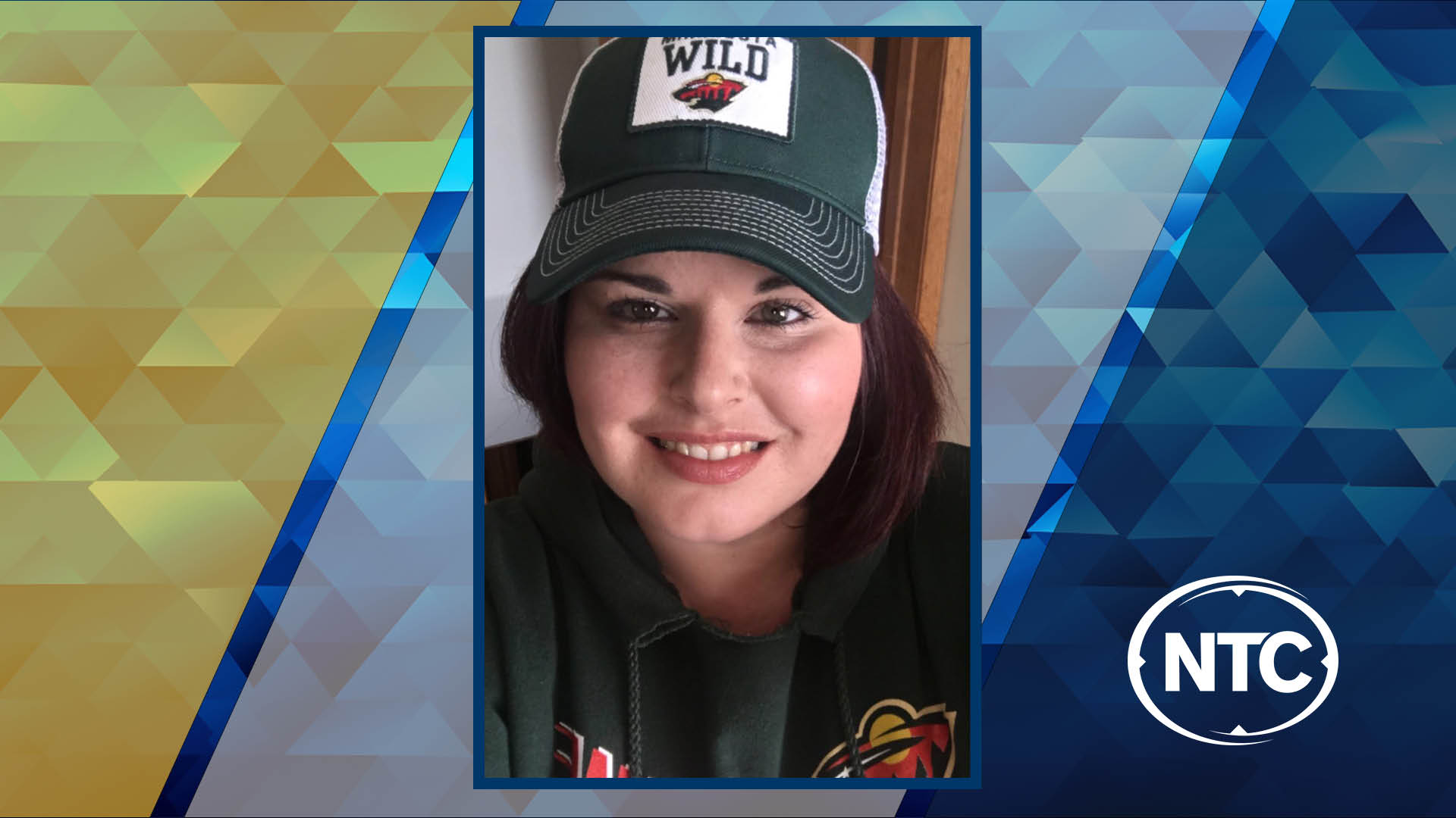 A portrait of a woman with long brown hair wearing a Minnesota Wild jacket and cap.