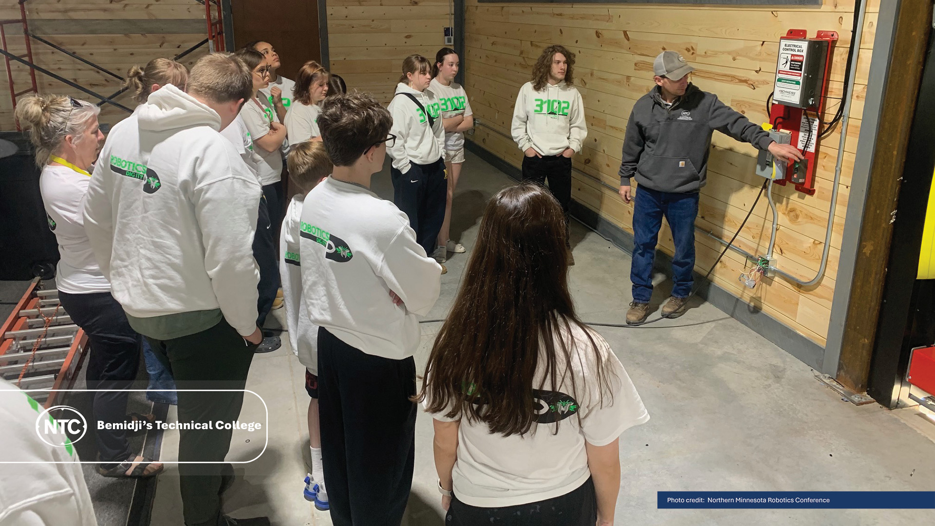 Grant Foss, NTC electrical faculty, explains an electrical control box to Nevis High School robotics students.