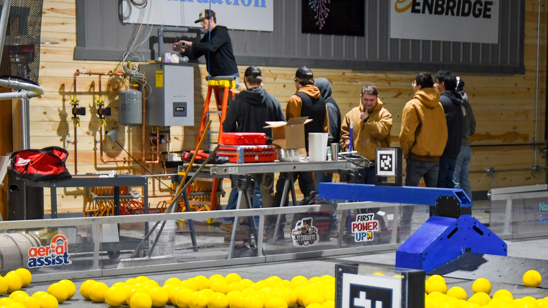 NTC students install a ventilation pipe onto a boiler at the North STAR Robotics building in Bemidji.