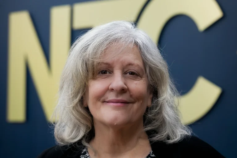 Headshot of Maggie in front of the NTC logo.