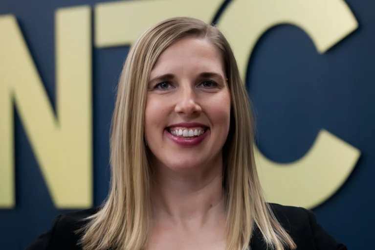 Headshot of Mindy in front of the NTC logo.