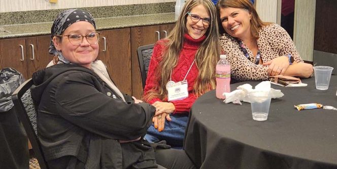 Three people at a conference table.