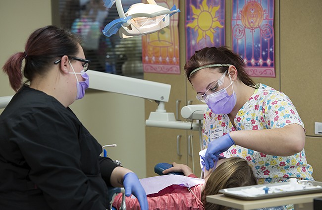 NTC student providing dental care during NTC's annual Give Kids a Smile free dental care event.