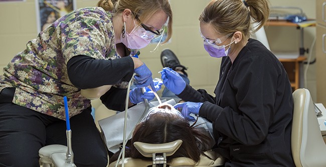NTC student providing dental care during NTC's annual Give Kids a Smile free dental care event.