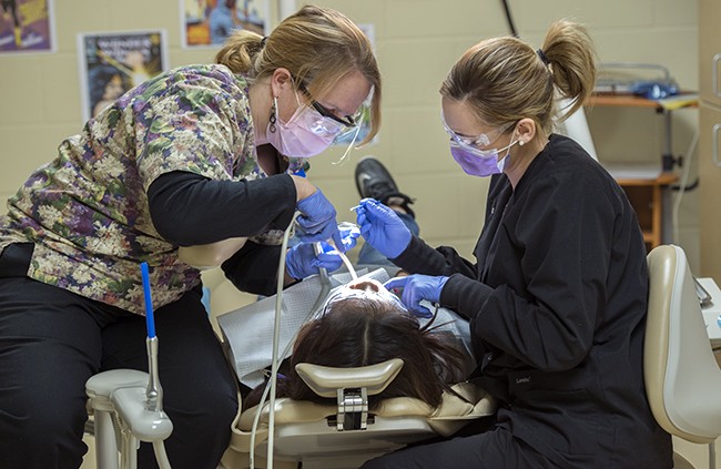 NTC student providing dental care during NTC's annual Give Kids a Smile free dental care event.