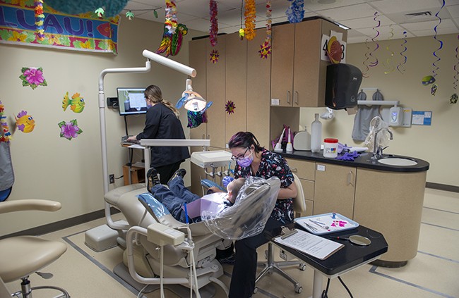 NTC student providing dental care during NTC's annual Give Kids a Smile free dental care event.