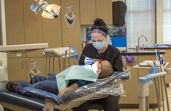 NTC student providing dental care during NTC's annual Give Kids a Smile free dental care event.