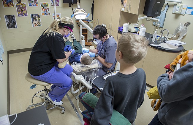 NTC student providing dental care during NTC's annual Give Kids a Smile free dental care event.