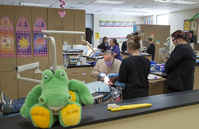 NTC student providing dental care during NTC's annual Give Kids a Smile free dental care event.