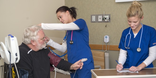 Students checking a patients blood pressure