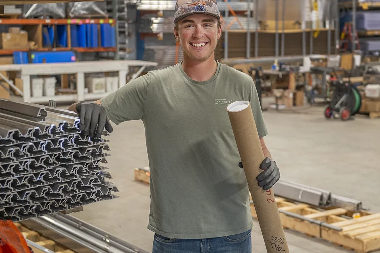 a student standing in a warehouse, smiling