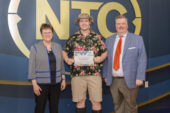 Tyler Hanson holding his most improved student award.