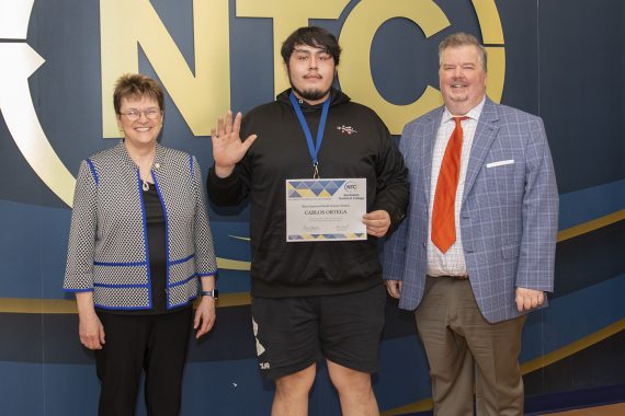 Carlos Ortega holding his most improved student award.