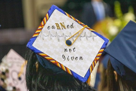 A graduation cap with decorated with the words "eaRNed not given"