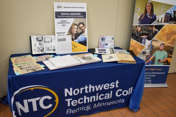 A photo of a table with historical photos and other documents related to the 50th anniversary of dental assisting at NTC
