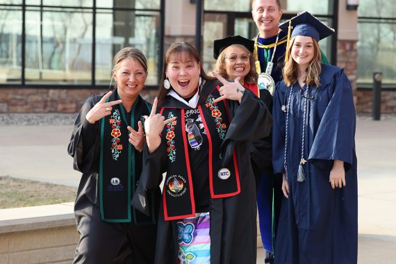 NTC faculty, staff and Outstanding Minnesotan, Tuleah Palmer, pose for a photo with a student