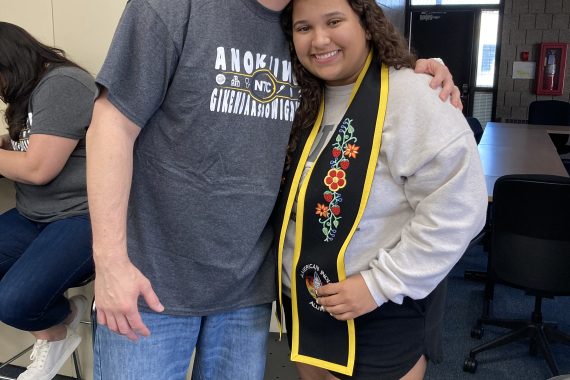 An NTC student poses for a photo wearing her stole