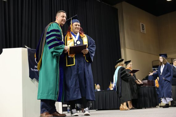 An NTC graduate poses for a photo with President Hoffman